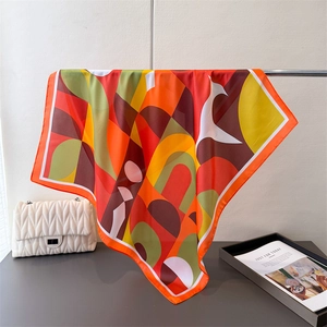 Carré de soie aux motifs géométriques abstraits dans des tons orange et rouge vifs