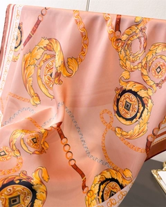 Macro detail of silk-like satin scarf featuring baroque chain prints and draped texture