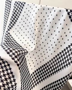 Vue détaillée du foulard en soie pied-de-poule montrant la texture satinée et les plis