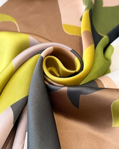 Macro shot of satin silk scarf featuring artistic geometric patterns and glossy texture