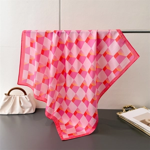 Détail d'un foulard en soie rose à motif cube 3D géométrique avec texture satinée lisse