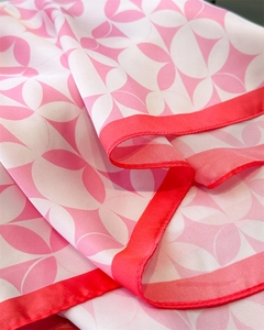 Detail of pink floral silk scarf showing premium texture and neat edge stitching