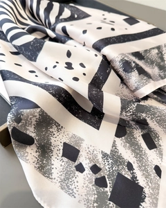 Détail macro du foulard en soie à imprimé zèbre noir et blanc avec motifs géométriques
