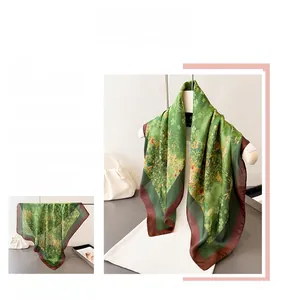 Detailed macro view of semi-transparent green silk scarf with delicate floral print and red border