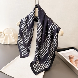 Foulard en soie à motif pied-de-poule classique sur un pull en maille blanc et cintre
