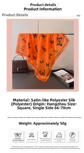 Detail of silk-like satin square scarf featuring orange butterfly print and soft texture