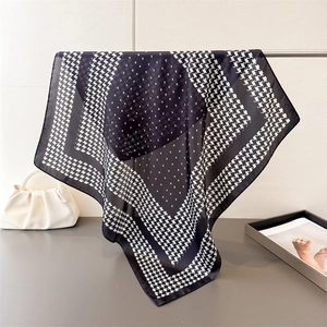 Détail de motif pied-de-poule élégant sur un foulard carré en soie bleu marine