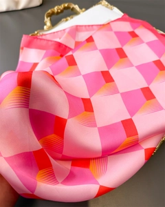 Gros plan détaillé du foulard en soie à carreaux rose et orange au fini satiné brillant