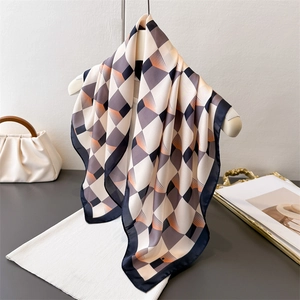 Détail d'un foulard en soie à motif géométrique suspendu sur un cintre élégant