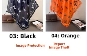 Detail of elegant silk scarves with butterfly prints in black and orange over a leather bag