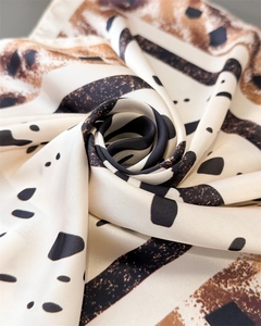 Gros plan du foulard en satin à imprimé zèbre et léopard plié en forme de rose