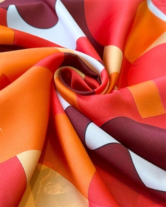 Vue macro d'un foulard en soie aux motifs géométriques abstraits rouges et orange