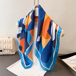 Foulard géométrique en satin de soie avec motifs bleu marine et orange sur mannequin