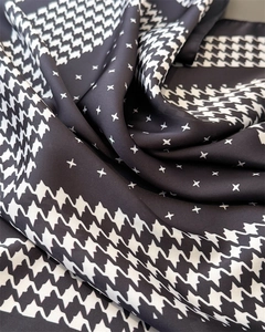 Détail du tissu en satin soyeux avec motifs pied-de-poule et étoiles noir et blanc