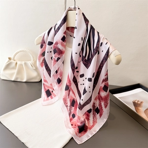 Foulard en imitation soie rose avec motifs zébrés et accents tie-dye sur un cintre