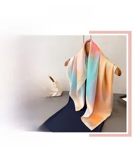 Detail of gradient silk scarf in orange, yellow, and blue with premium hemmed edges