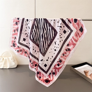 Vue détaillée d'un foulard en satin à motif zèbre avec bordure rouge sur support