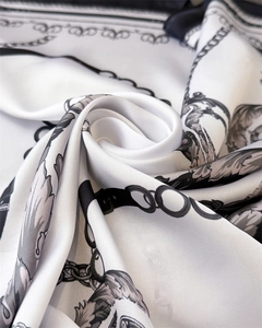 Macro detail of silk scarf showing elegant chain print and smooth satin fabric texture