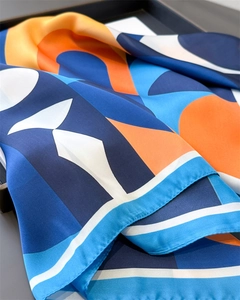 Gros plan détaillé d'un foulard en soie aux motifs géométriques bleu et orange