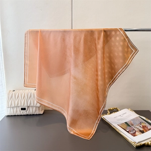 Detail of amber silk square scarf with micro polka dots and white contrast edges