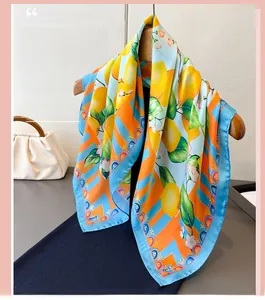 Detail of floral print silk scarf with lemon pattern hanging on a wooden hanger