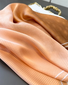 Detail shot of gradient silk scarf with polka dot pattern showing smooth satin texture