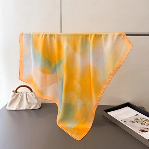 Close-up of silk square scarf showing colorful gradient dye and soft texture draping