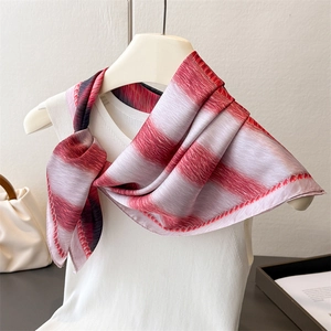 Detail of red and pink striped faux silk scarf with premium rolled edges on white top