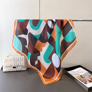 Détail de foulard en satin aux motifs géométriques et bordures roulées précises