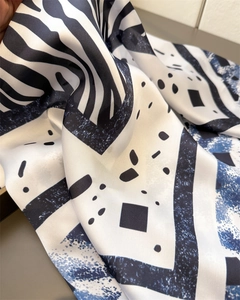 Détail d'un foulard en satin soyeux avec imprimé zèbre bleu et motifs géométriques