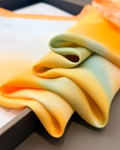 Close-up of silk-like gradient scarf showing yellow to green transition and fine edge detail