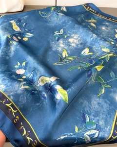 Close-up of elegant dark blue floral silk scarf with artistic print and smooth texture