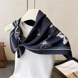 Detail of silk satin scarf with white butterfly pattern and elegant soft sheen texture