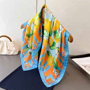 Detail of vibrant floral silk scarf with lemon print and elegant light blue hem