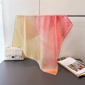 Detail of soft yellow to pink gradient silk scarf with white polka dot texture pattern