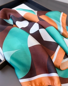 Détail d'un foulard en soie à motif géométrique et éclat satiné sur plateau