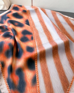 Detail view of the orange leopard print and striped silk scarf with fine edge stitching