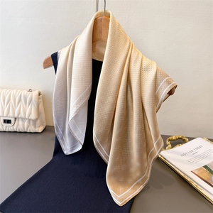 Elegant champagne gradient silk scarf with polka dots hanging on a wooden hanger