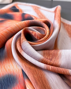 Detailed view of luxury faux silk square scarf featuring orange and grey leopard prints