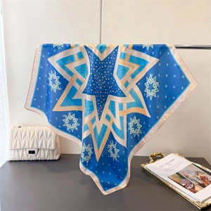 Detailed view of navy blue geometric star silk scarf with pink rolled edges and subtle gloss