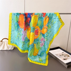 Detail of silk scarf showing tropical fruit patterns and yellow scalloped edges