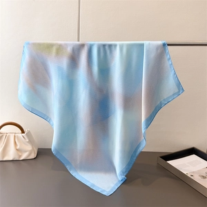 Detailed view of the gradient silk scarf with blue and gray abstract patterns