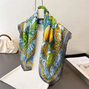 Elegant silk scarf featuring vibrant lemon print and deep grey border on white model
