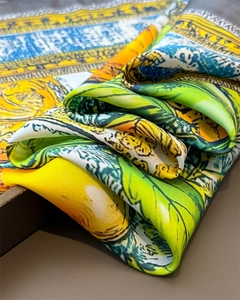 Detail showing smooth silk texture and artistic botanical print on vibrant scarf
