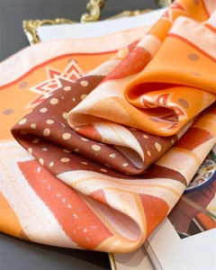 Macro view of silky scarf with vintage geometric patterns in warm orange and brown tones