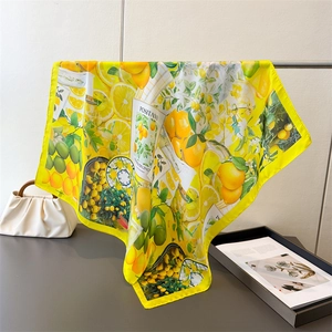 Detailed pattern of a square silk scarf featuring bright Positano lemons and citrus print