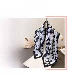 Detail of checkered silk scarf showing black and white wavy patterns and soft texture