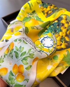 Detail of silk scarf showing lemon prints and blue tile patterns in vivid yellow