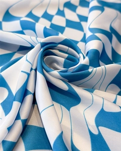Close-up of sky blue and white wavy checkerboard pattern on soft faux silk fabric scarf