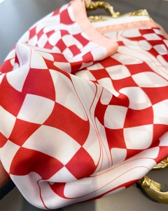 Detail of red and white checkered silk scarf on a vintage gold tray showing satin luster